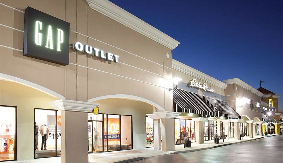 Evening exterior photo of Lake Buena Vista Factory Stores. Featuring GAP Outlet, Eddie Bauer, Sony, JVC, and Loft. Lake Buena Vista, Florida.