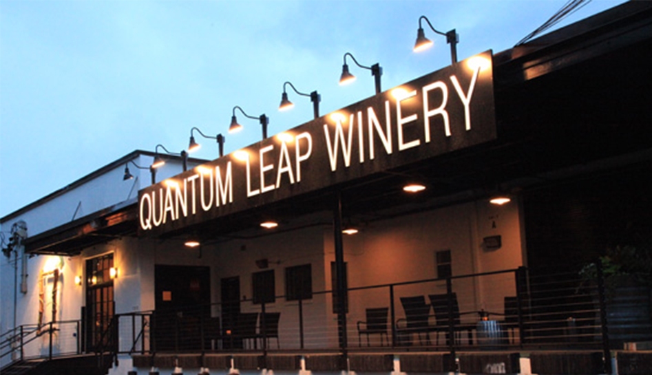 Late afternoon photo of entrance to Quantum Leap Winery (lights lit on sign). Orlando, Florida.