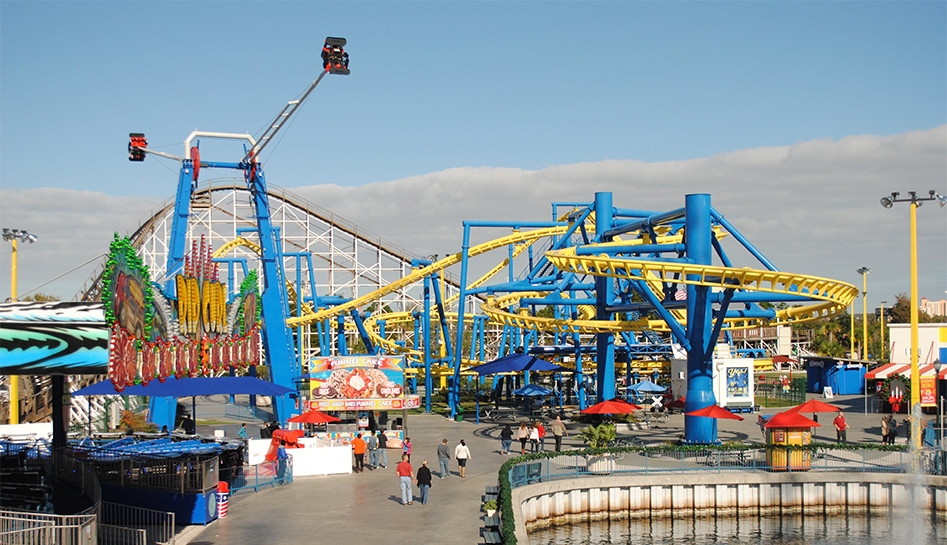 A distant daytime shot of Fun Spot Orlando and all of its attractions as guests walk around. Orlando, Florida.