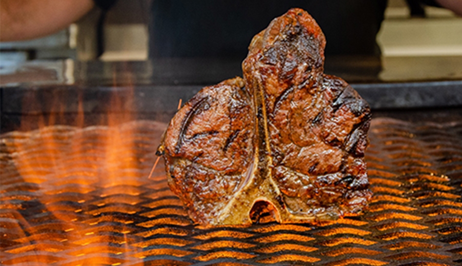 A piece of steak on a fire grill at Charley's Steakhouse & Seafood Grille. Orlando, Florida.